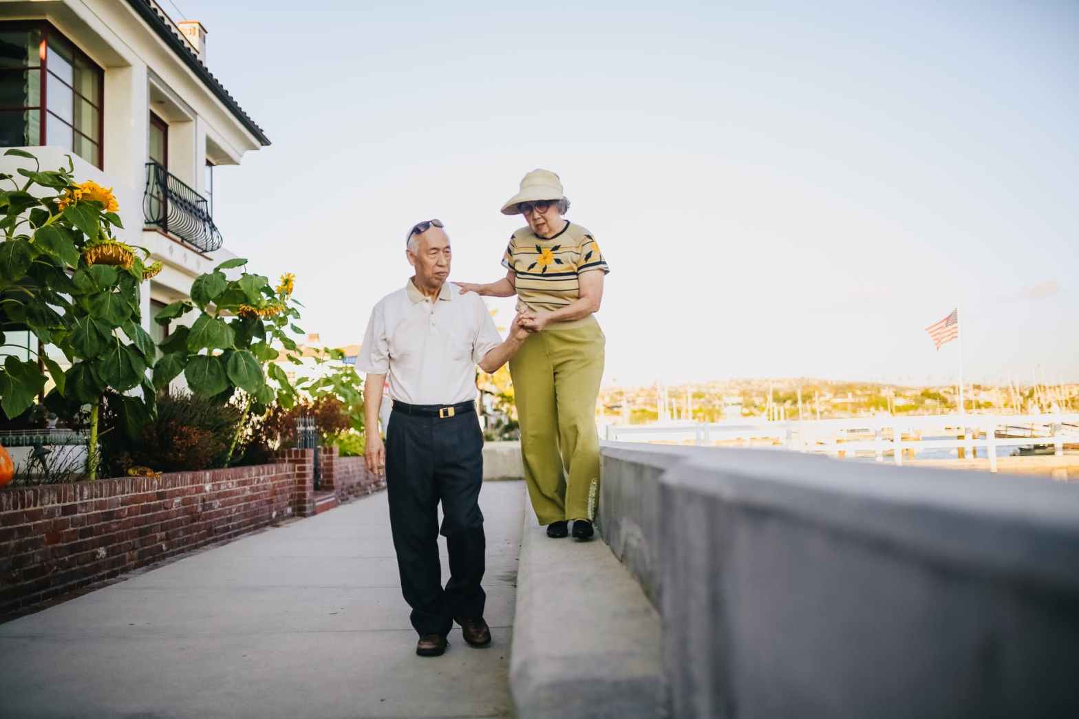 man and woman walking on gray concrete bench
