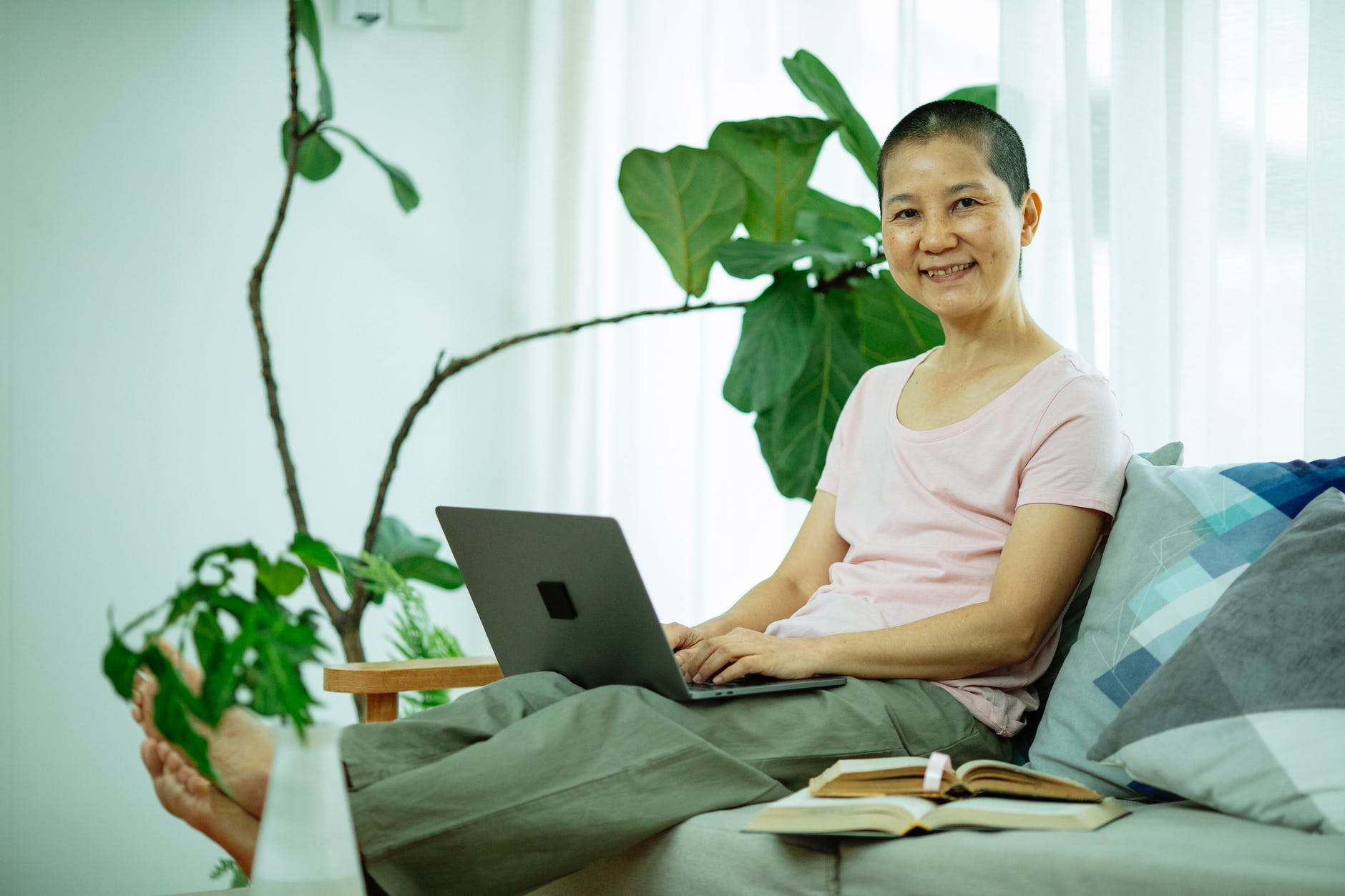 happy asian lady using netbook on couch in living room