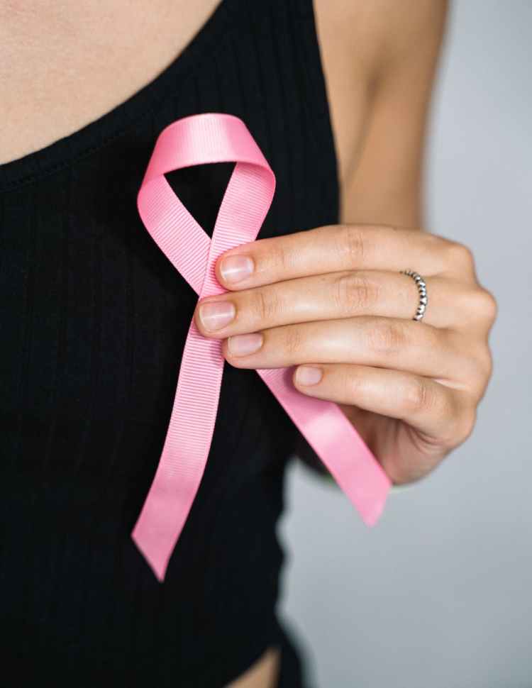 woman in black tank top holding pink ribbon